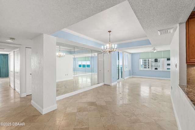 2987 S Atlantic Ave Unit 903, Daytona Beach Shores, FL 32118 - spare room featuring a chandelier, ornamental molding, baseboards, a raised ceiling, and a ceiling fan