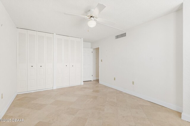 2987 S Atlantic Ave Unit 903, Daytona Beach Shores, FL 32118 - unfurnished bedroom with two closets, baseboards, ceiling fan, and light flooring