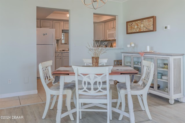 dining space with a chandelier and light wood-type flooring