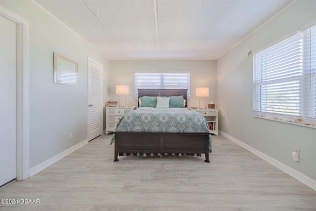 bedroom featuring light hardwood / wood-style floors and a textured ceiling