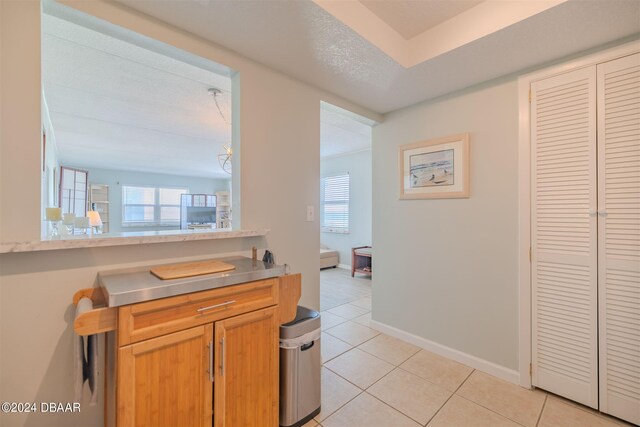 kitchen featuring a textured ceiling, a healthy amount of sunlight, and light tile patterned floors