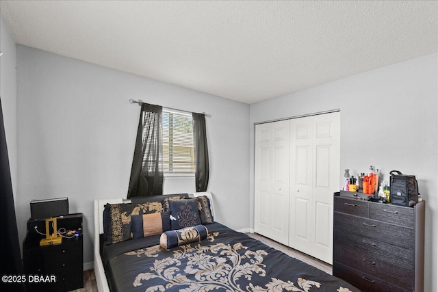 bedroom featuring a textured ceiling, a closet, and wood finished floors