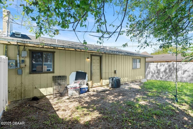 back of property with fence and central AC unit