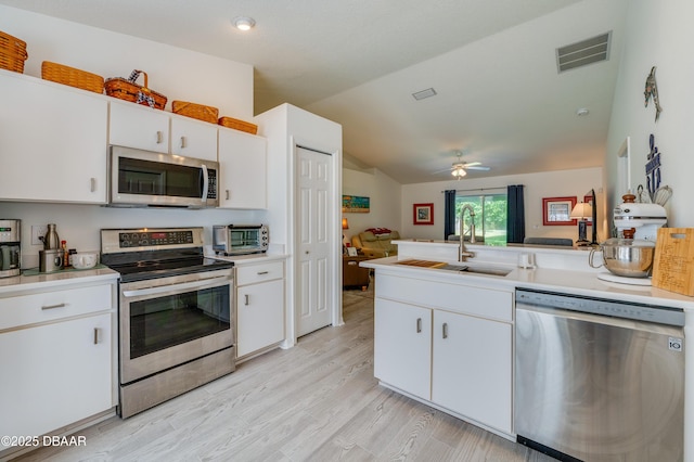 49 Felshire Ln, Palm Coast, FL 32137 - kitchen with stainless steel appliances, vaulted ceiling, open floor plan, white cabinets, and light countertops
