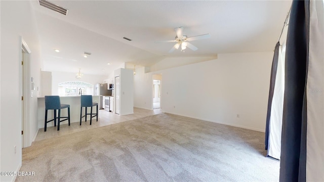 49 Felshire Ln, Palm Coast, FL 32137 - living room with light carpet, ceiling fan, vaulted ceiling, and baseboards