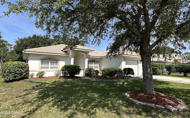 49 Felshire Ln, Palm Coast, FL 32137 - mediterranean / spanish-style home with an attached garage, a tiled roof, a front yard, stucco siding, and concrete driveway