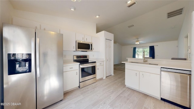 49 Felshire Ln, Palm Coast, FL 32137 - kitchen with stainless steel appliances, lofted ceiling, ceiling fan, a sink, and white cabinetry
