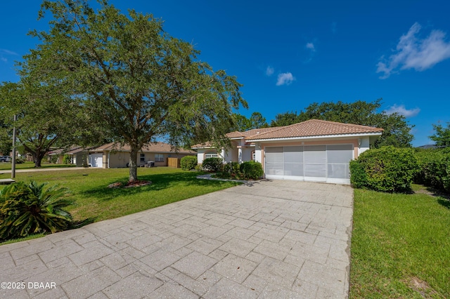 49 Felshire Ln, Palm Coast, FL 32137 - view of front of home featuring a garage, driveway, a front lawn, stucco siding, and a tiled roof