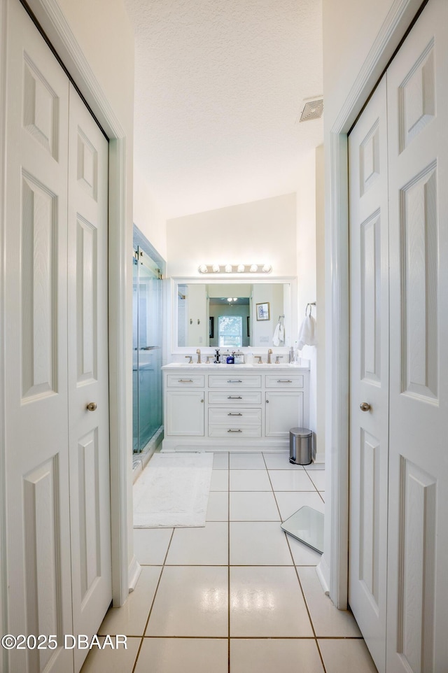 49 Felshire Ln, Palm Coast, FL 32137 - bathroom featuring a closet, tile patterned floors, double vanity, and a stall shower