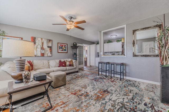 living room with ceiling fan and baseboards