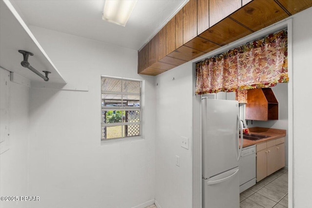 kitchen featuring sink, white appliances, and light tile patterned flooring