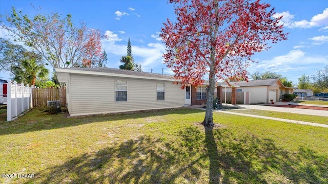 view of front facade with a garage, central AC unit, and a front yard