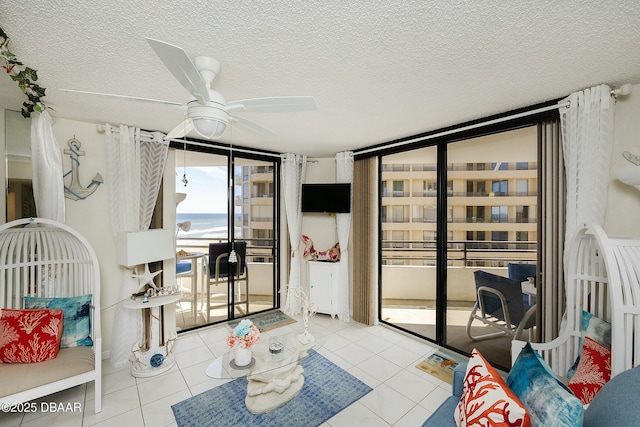 living room with tile patterned flooring, floor to ceiling windows, a textured ceiling, and ceiling fan