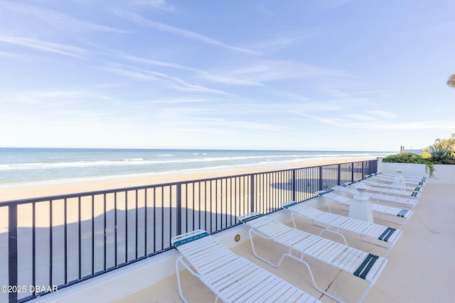 balcony featuring a beach view and a water view