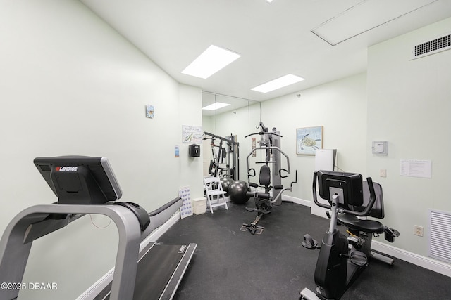 workout area featuring visible vents, attic access, and baseboards