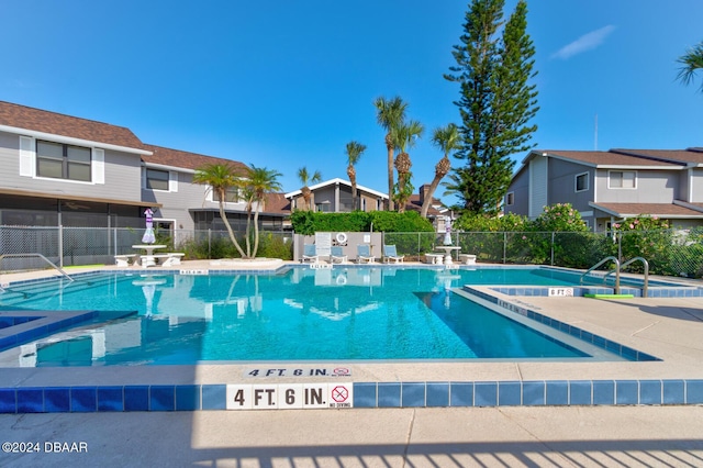 118 Lagoon Ct, New Smyrna Beach, FL 32169 - community pool featuring a patio area, fence, and a residential view