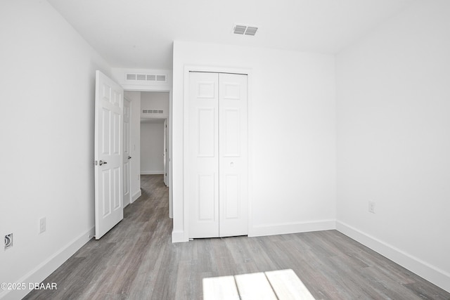 unfurnished bedroom with a closet and light hardwood / wood-style floors