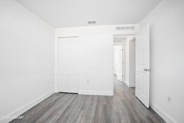 unfurnished bedroom featuring a closet and hardwood / wood-style floors