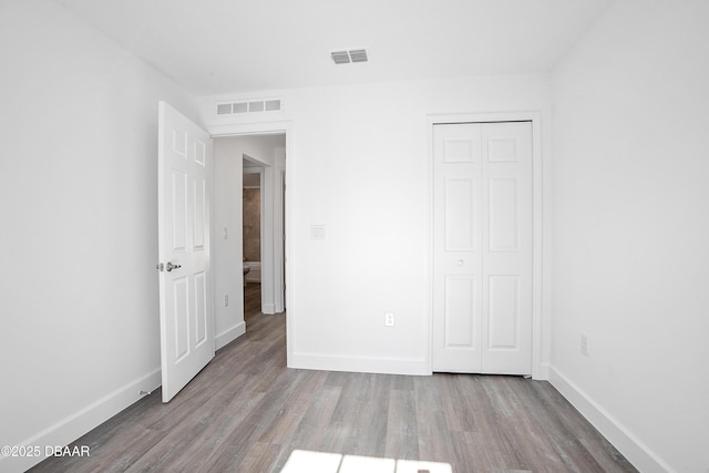 unfurnished bedroom with light wood-type flooring and a closet