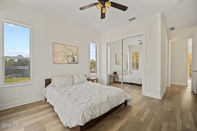 bedroom featuring multiple windows, hardwood / wood-style flooring, and a closet