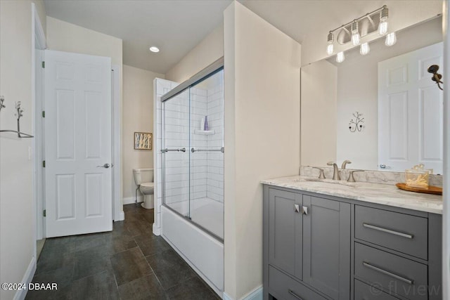 full bathroom with vanity, shower / bath combination with glass door, and toilet