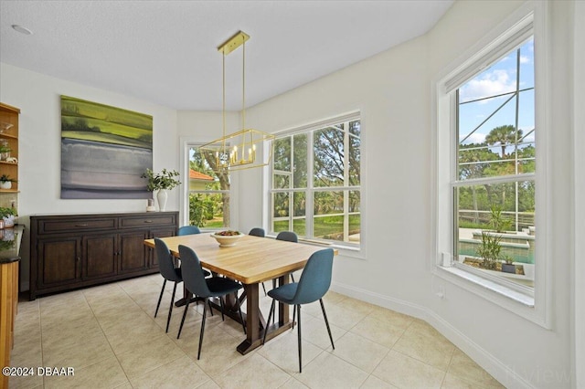 tiled dining space with a notable chandelier and a textured ceiling