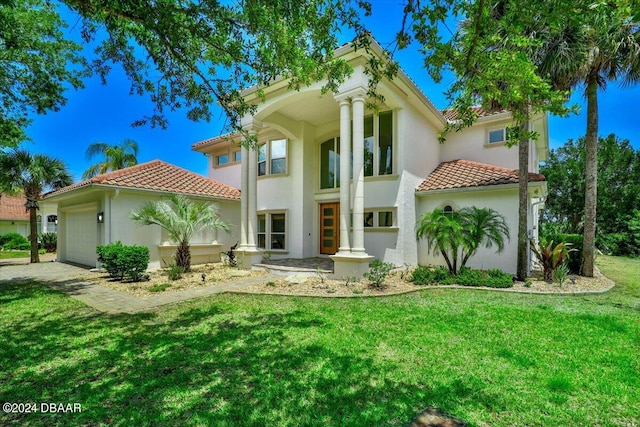 view of front of property with a garage and a front lawn