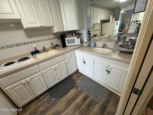 kitchen with white appliances, white cabinetry, sink, and dark hardwood / wood-style flooring