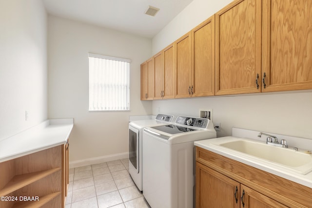 laundry area with cabinets, sink, independent washer and dryer, and light tile patterned floors