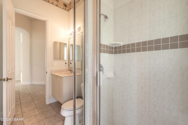 bathroom featuring tile patterned flooring, vanity, toilet, and an enclosed shower