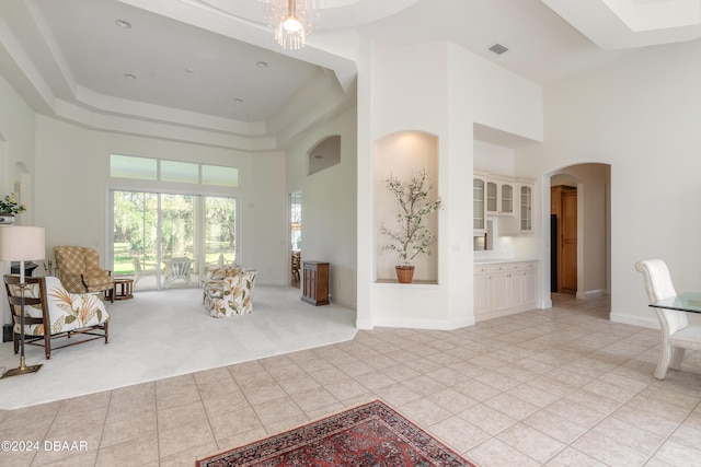 unfurnished living room featuring a towering ceiling and light tile patterned floors