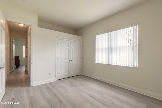 unfurnished bedroom featuring a closet and light wood-type flooring