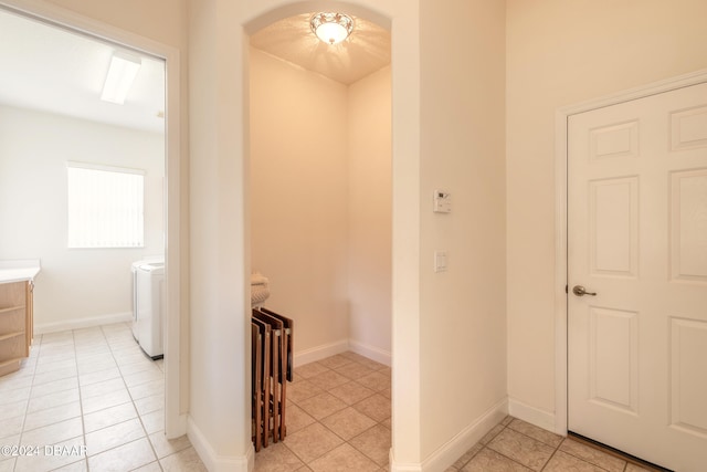 hall featuring washing machine and clothes dryer, radiator, and light tile patterned floors