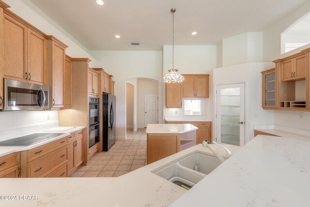 kitchen featuring black appliances, hanging light fixtures, and sink