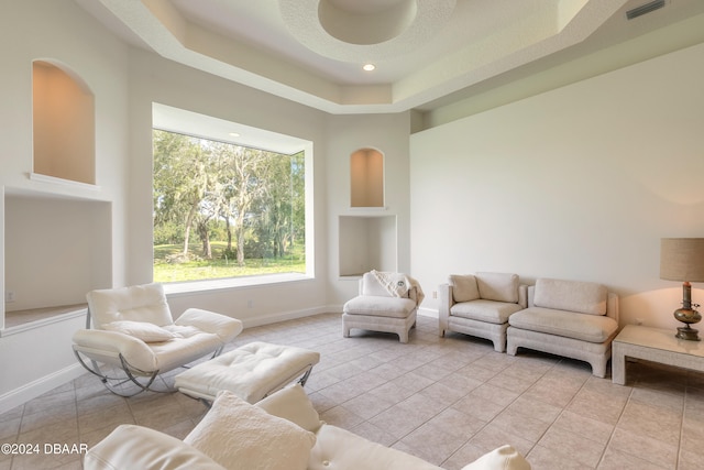 tiled living room featuring a tray ceiling