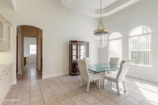 dining space with light tile patterned flooring and a high ceiling