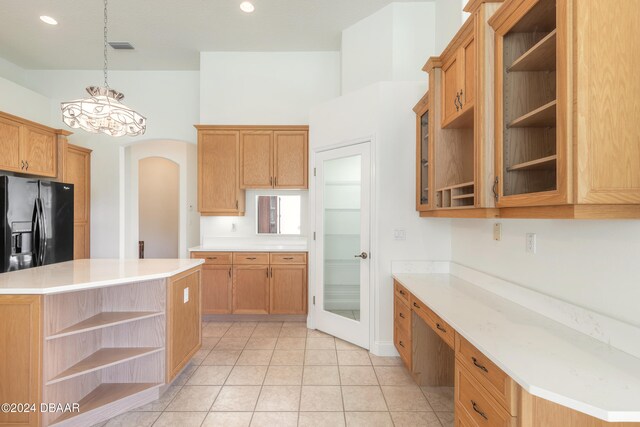 kitchen featuring light tile patterned floors, a notable chandelier, black fridge with ice dispenser, and a center island