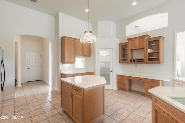 kitchen featuring high vaulted ceiling, a kitchen island, hanging light fixtures, and light tile patterned floors