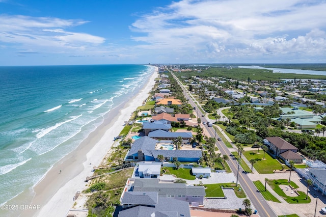 birds eye view of property with a water view and a view of the beach