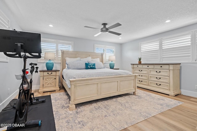 bedroom featuring ceiling fan, a textured ceiling, and light hardwood / wood-style flooring