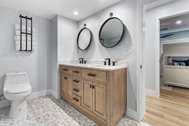 bathroom with hardwood / wood-style floors, toilet, and vanity