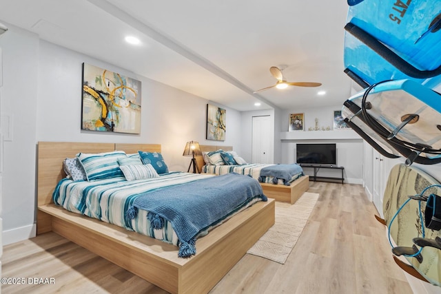 bedroom featuring ceiling fan, light hardwood / wood-style floors, and a closet