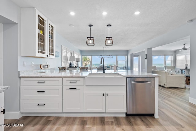 kitchen with dishwasher, white cabinets, light stone countertops, light hardwood / wood-style flooring, and sink