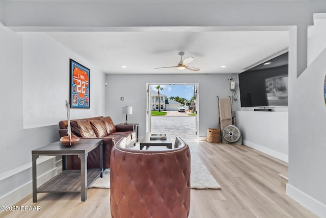 living room with ceiling fan and light hardwood / wood-style flooring