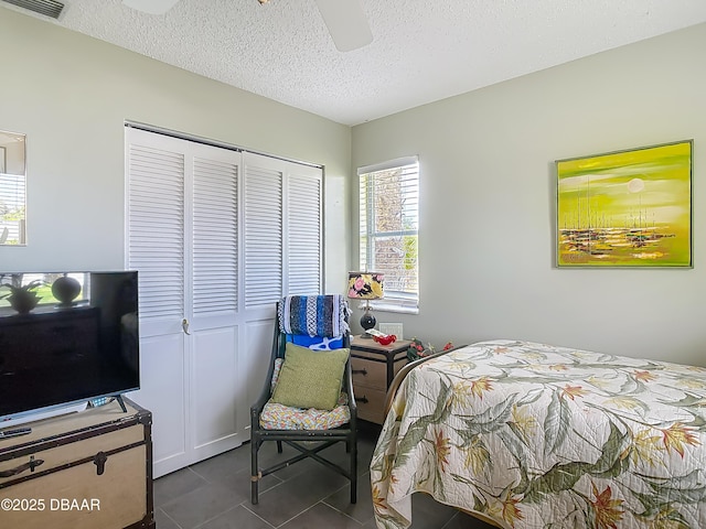 31 Sea Harbor Dr E Unit E, Ormond Beach, FL 32176 - bedroom with a closet, dark tile patterned flooring, a textured ceiling, and ceiling fan