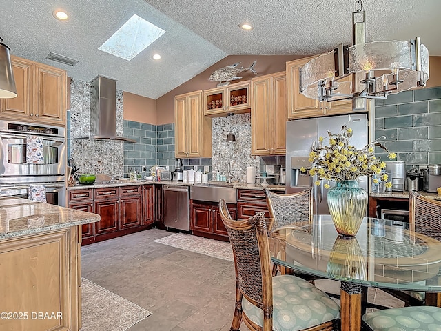31 Sea Harbor Dr E Unit E, Ormond Beach, FL 32176 - kitchen with wall chimney range hood, appliances with stainless steel finishes, a skylight, tasteful backsplash, and a textured ceiling