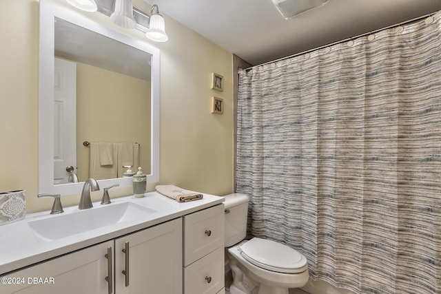 bathroom with curtained shower, vanity, and toilet