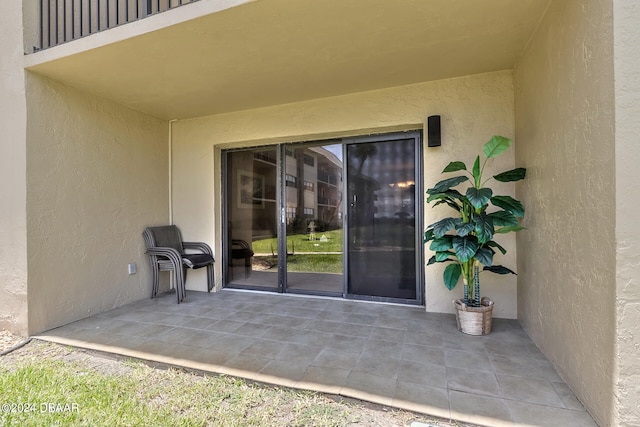 view of exterior entry with a patio area