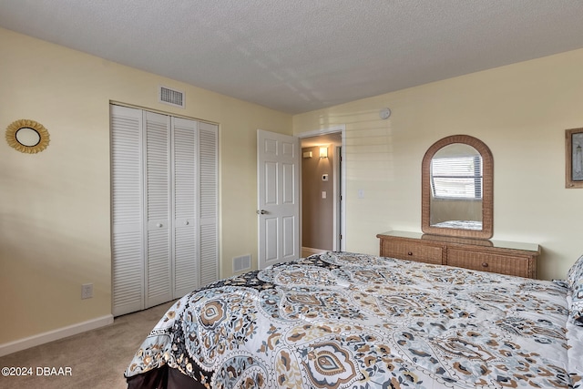 carpeted bedroom with a closet and a textured ceiling