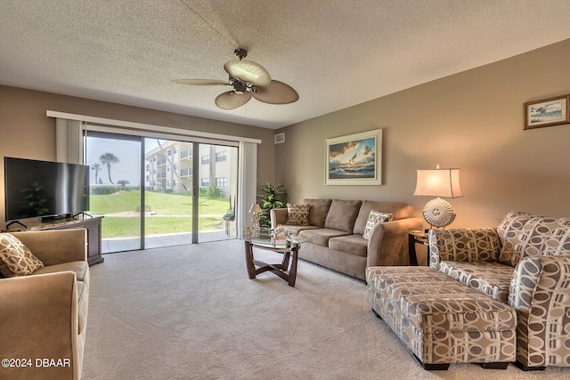 carpeted living room featuring a textured ceiling and ceiling fan